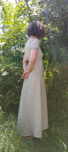 Charger l&#39;image dans la galerie, robe longue en lin beige, style regency, manche courtes, portées par Maureen, la creatrice de pret à porter, pieds nus dans l&#39;herbe