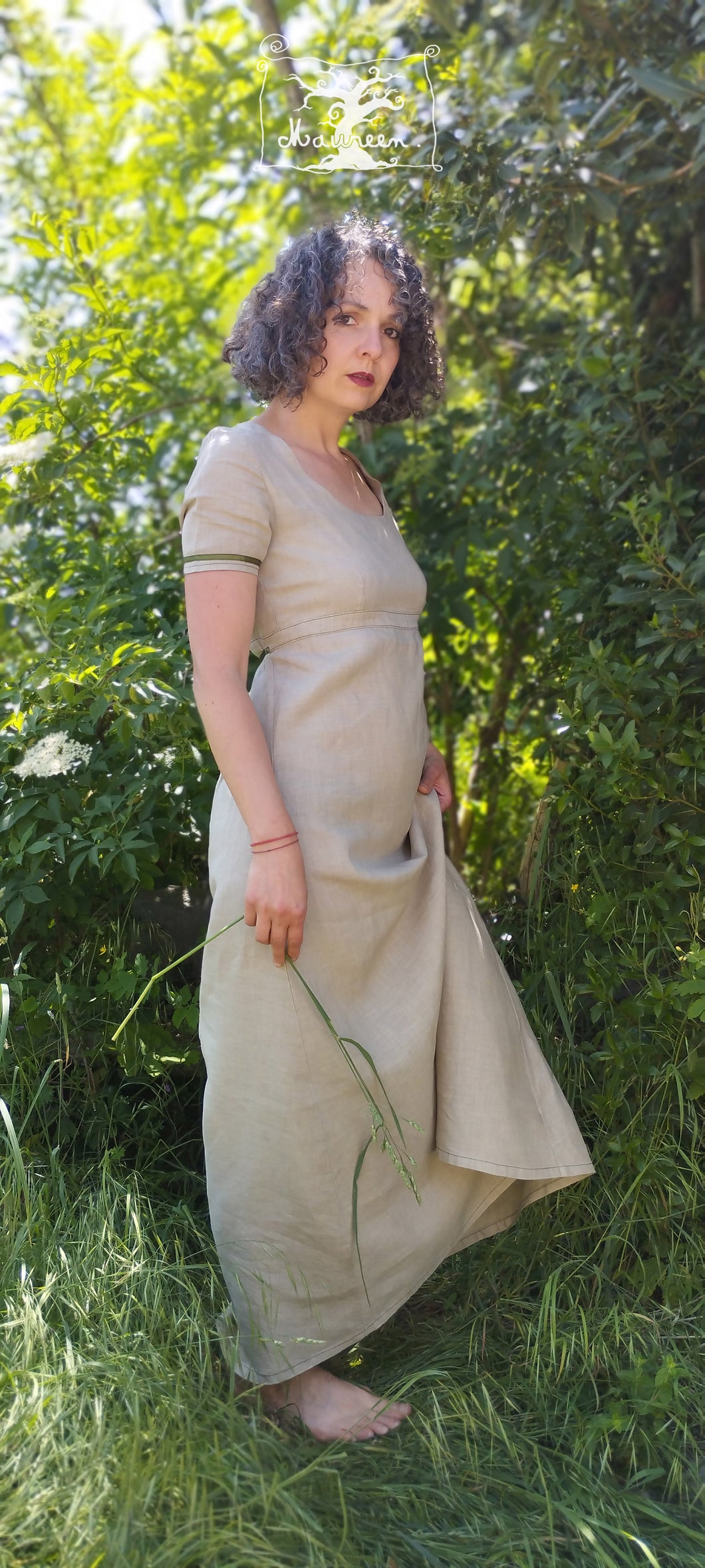robe longue en lin beige, style regency, manche courtes, portées par Maureen, la creatrice de pret à porter, pieds nus dans l'herbe