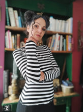 Charger l&#39;image dans la galerie, femme brune portant un tee shirt rayé noir et blanc devant une bibliotheque. créatrice Maureen Vinot