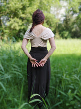 Charger l&#39;image dans la galerie, femme debout de dos dans une prairie aux herbes hautes, elle porte un tee shirt en jersey beige. Ses cheveux auburn sont tressés.
Création Maureen Vinot