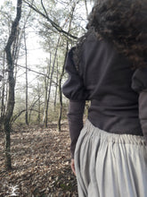 Charger l&#39;image dans la galerie, femme qui marche dans la forêt et habillée d&#39;une longue jupe de lin fluide. D&#39;un pull beige à manches bouffantes. Ces vêtements sont ceux de la créatrice Maureen. Ils sont fabriqués en Bretagne