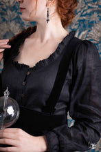 Charger l&#39;image dans la galerie, jeune femme rousse habillée d&#39;un chemisier en lin noir porté avec une jupe tablier noire en velours. création créatrice Maureen