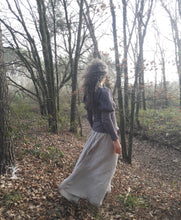Charger l&#39;image dans la galerie, femme qui marche dans la forêt et habillée d&#39;une longue jupe de lin fluide. D&#39;un pull beige à manches bouffantes. Ces vêtements sont ceux de la créatrice Maureen. Ils sont fabriqués en Bretagne